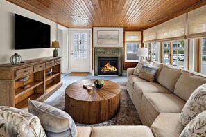 A living room with a fireplace, a television, a sofa, and a coffee table. - NEW TO VRBO: 9 BR-7.5 BA RENOVOTED REHOBOTH BEAUTY-STEPS TO SAND-6 NEW CASTLE (Rehoboth Beach)