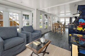 A spacious living area with a sofa, a coffee table, and a patterned wall. - NEW TO VRBO: 9 BR-7.5 BA RENOVOTED REHOBOTH BEAUTY-STEPS TO SAND-6 NEW CASTLE (Rehoboth Beach)