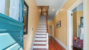 A staircase with wooden steps and white railings, leading to a landing with a door. - Savannah Home, Walkable to Forsyth, Historic (Savannah)