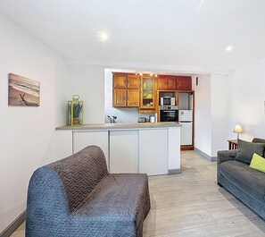Un apartament modern amb cuina, zona d'estar i menjador.
