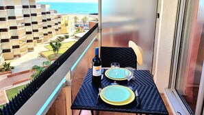 A balcony with a table set for two, overlooking a residential area and the sea. - Canet-en-Roussillon: Studio for 2 with balcony (Canet-en-Roussillon)