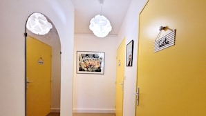 A hallway with yellow doors, white walls, and a framed picture on the wall. - Canet-en-Roussillon: Studio for 2 with balcony (Canet-en-Roussillon)