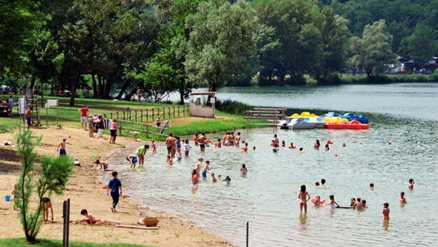 Un parque frente al lago con playa de arena y muelle.