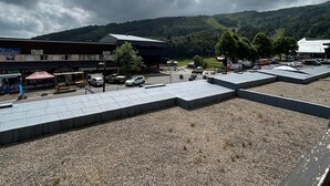 A parking lot with several cars, a building with a sign that reads "Katia," and a mountainous landscape in the background. - Studio in Station Center with Free Wi-Fi (Besse-et-Saint-Anastaise-Super Besse)