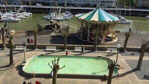 Uma marina com barcos, um carrossel e uma piscina.