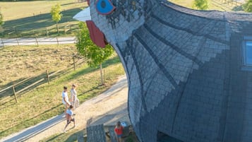 Een groot, opvallend gebouw in de vorm van een kip, met een verhard pad er naartoe.