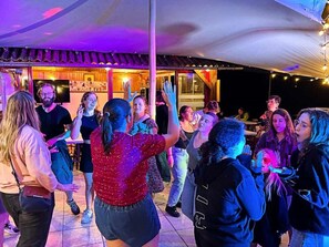 A group of people dancing in an outdoor area with a covered seating area and a stage in the background. - Spacious 3-Bedroom Mobile Home for 6 People - Terrace (Concourson-sur-Layon)