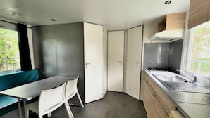 Una cucina compatta con zona pranzo, una finestra e piano cottura integrato.
