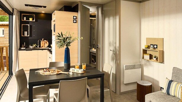 A compact living space with a dining area, kitchenette, and a cozy seating area. - Spacious chalet with terrace for 5 people (Nibelle)