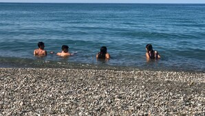 A pebbled beach with four people swimming in the water. - 4 Bedrooms 4 Bathrooms Pompeii 900 meters from the center (Pompei)