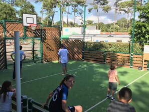 An outdoor basketball court with a green surface, surrounded by a wooden fence and trees. - Functional Mobile Home in Jard-sur-Mer, 3 Bedrooms, Sleeps 6 (Jard-sur-Mer)
