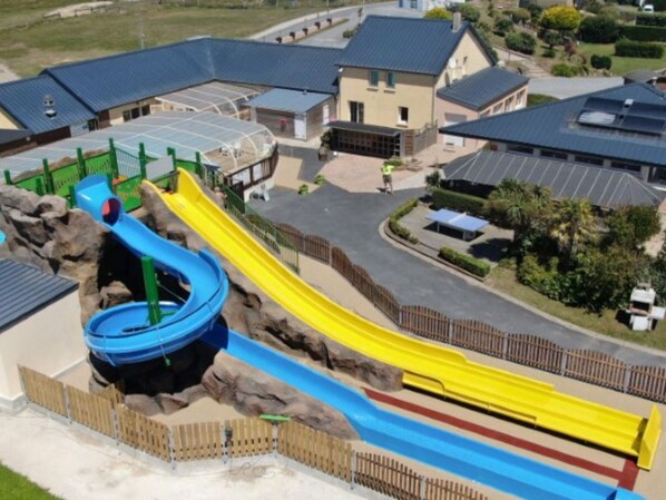 A playground with multiple slides and a climbing structure.
