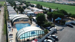 A camping site with a swimming pool, lounge chairs, and a parking area. - Mobile home with terrace for 4 people, near the beach (La Faute-sur-Mer)