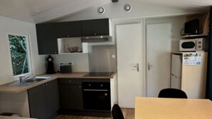 A compact kitchen with dark cabinets, a microwave, and a toaster. - Chalet for 6 with Terrace and Equipped Kitchen (Lamontjoie)