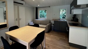 A compact kitchen with a dining table, chairs, a built-in bench, and a window. - Chalet for 6 with Terrace and Equipped Kitchen (Lamontjoie)
