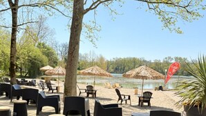 An outdoor seating area with thatched umbrellas, black chairs, and round stools. - Chalet for 6 with Terrace and Equipped Kitchen (Lamontjoie)