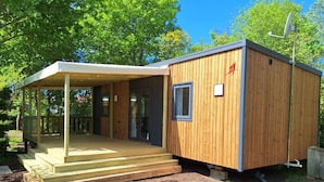 Eine kleine Holzhütte mit einer Veranda und einer Tür.