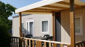 A covered outdoor area with a wooden deck, two tables, and chairs. - Mobile Home with Terrace for 4 People in La Faute-sur-Mer (La Faute-sur-Mer)