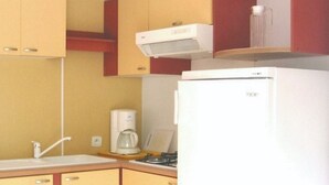 A kitchen with yellow cabinets, a white refrigerator, a coffee maker, and a microwave. - Mobile home 32m² with terrace, 3 bedrooms in Cavaillon, 8 pers. (Cavaillon)