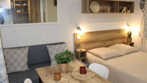 Ein gemütliches Schlafzimmer mit einem hölzernen Kopfteil, einem Nachttisch mit Lampe und einem kleinen Regal über dem Bett.