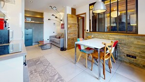 Une cuisine moderne avec un coin repas, dotée d’une grande fenêtre, d’un four encastré et d’une table à manger avec des chaises.