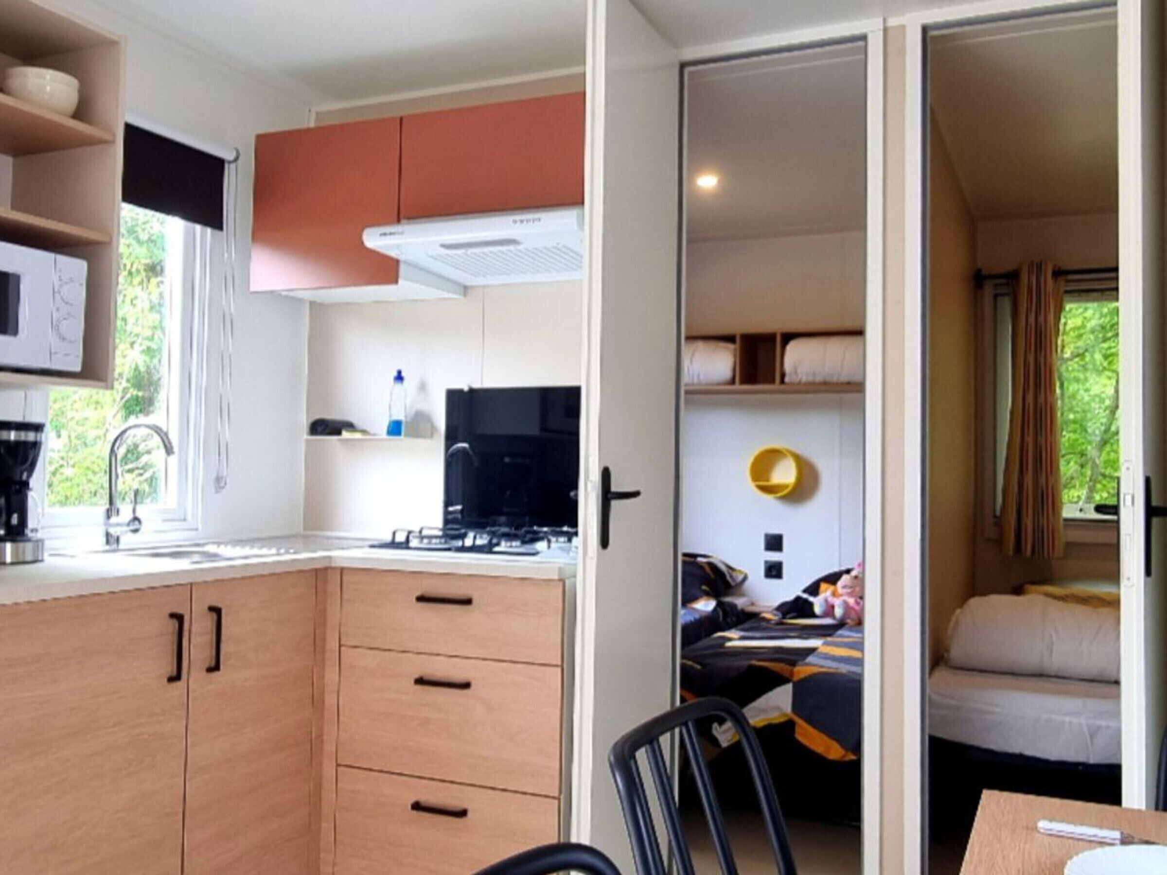 Una kitchenette compacta con estufa, lavamanos y armarios.