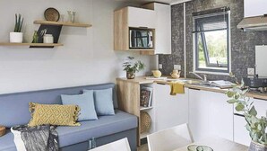 A compact kitchen with a built-in microwave, a sink, and a window. - Mobile home 4 guests - 2 bedrooms - Terrace (Saint-Julien-en-Born)