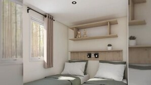 Ein Zimmer mit zwei Einzelbetten, einem Vorhangfenster und einem Regal mit Dekoration.