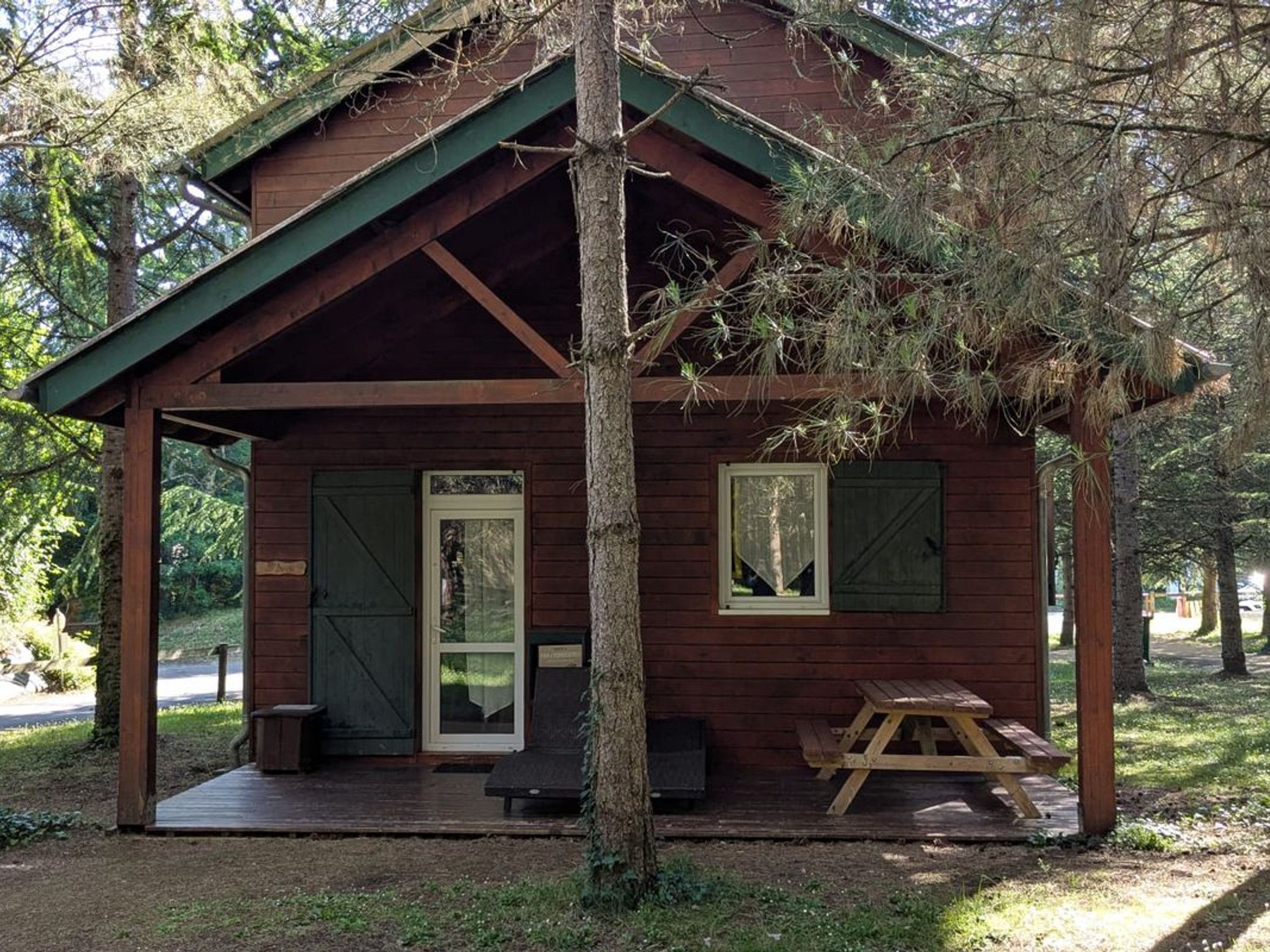 A small wooden cabin with a porch, a door, and a window.
