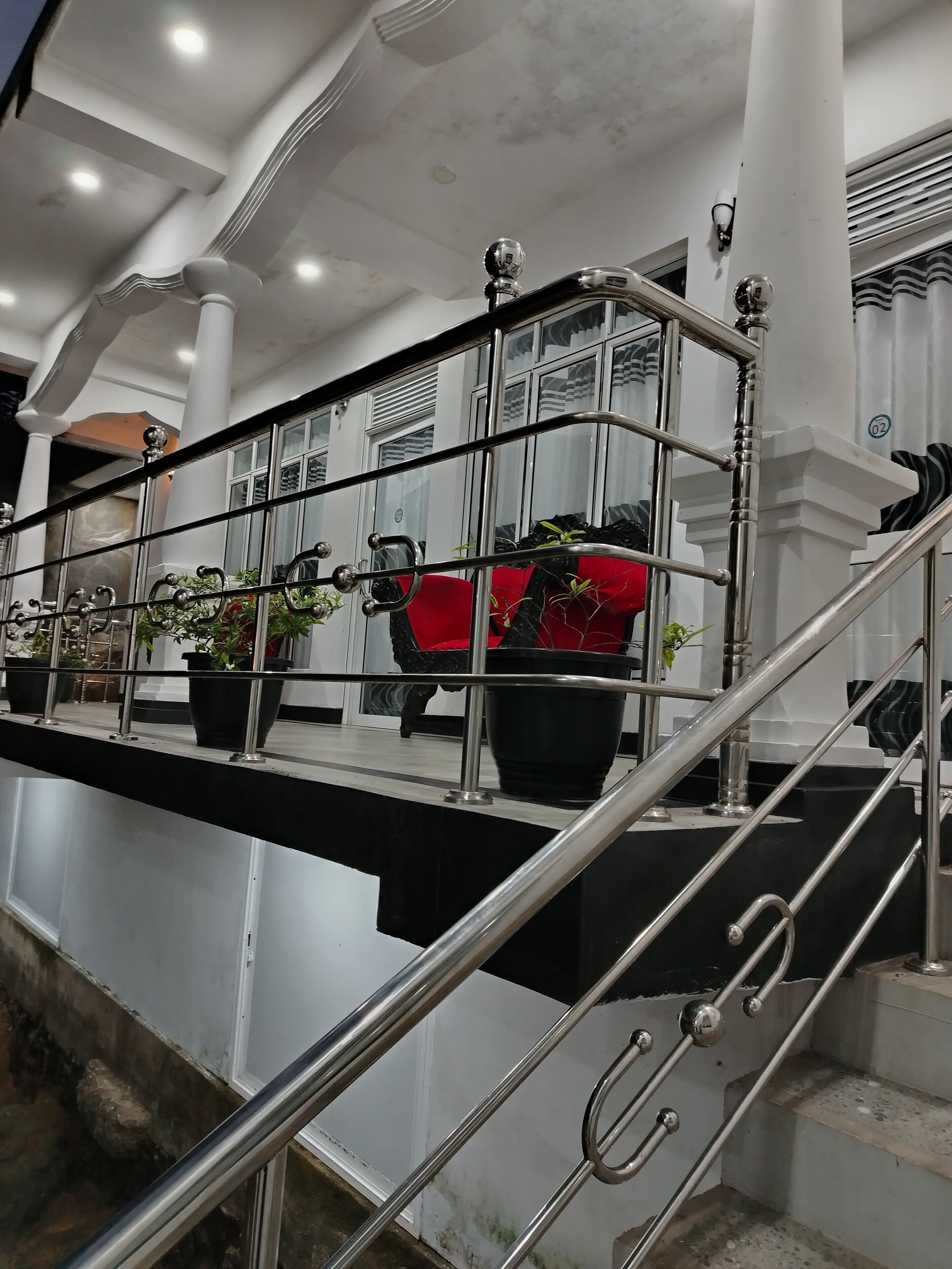A staircase with metal railings and potted plants.