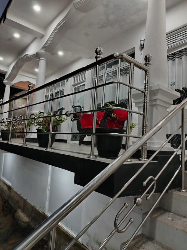 A staircase with metal railings and potted plants.