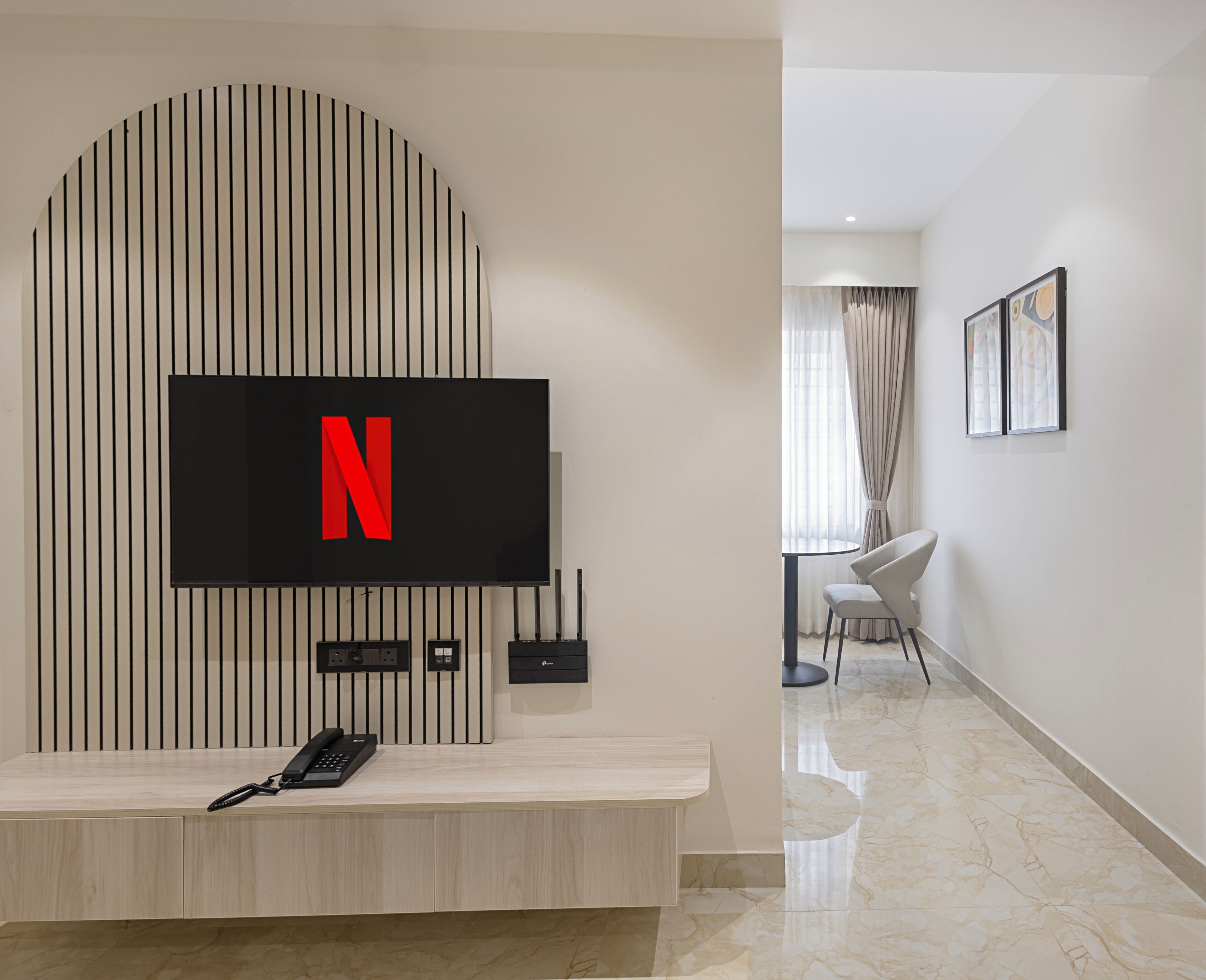 A modern living room with a mounted TV, a console table, and a wall-mounted telephone.