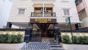 A hotel entrance with a sign reading "ELYSIUM premier suites".