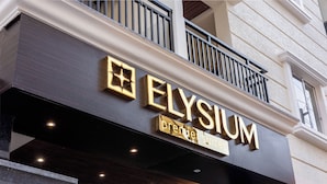 A hotel sign with the name "Elysium Premier Suites".