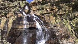 A waterfall cascading down a rocky cliff with a person standing at the base. - Mobile home 3 bedrooms for 6 people with garden furniture (Les Aires)