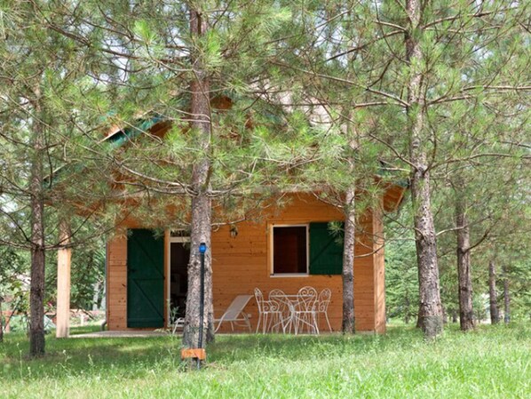 Une petite cabane en bois entourée d’arbres.