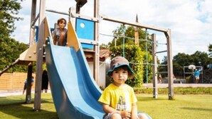 Ein Spielplatz mit einer blauen Rutsche und Klettergerüsten.