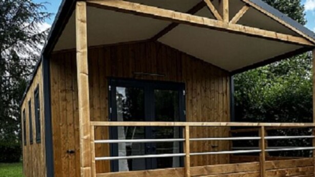 A wooden cabin with a porch and a door. - Mobile Home with Terrace in Charlieu, 6 Guests (Charlieu)