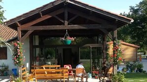 Un’area salotto esterna riparata, con panchine e cesti di fiori pensili.