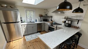 A modern kitchen with a central island, stainless steel appliances, and a skylight. - Downtown Newport Townhouse 2 Br/1.5 Bath/parking 2 Bedroom Apts (Newport)