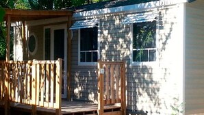 A small wooden cabin with a porch and steps leading to a door. - Comfortable Mobile Home with Terrace in Collias (Collias)