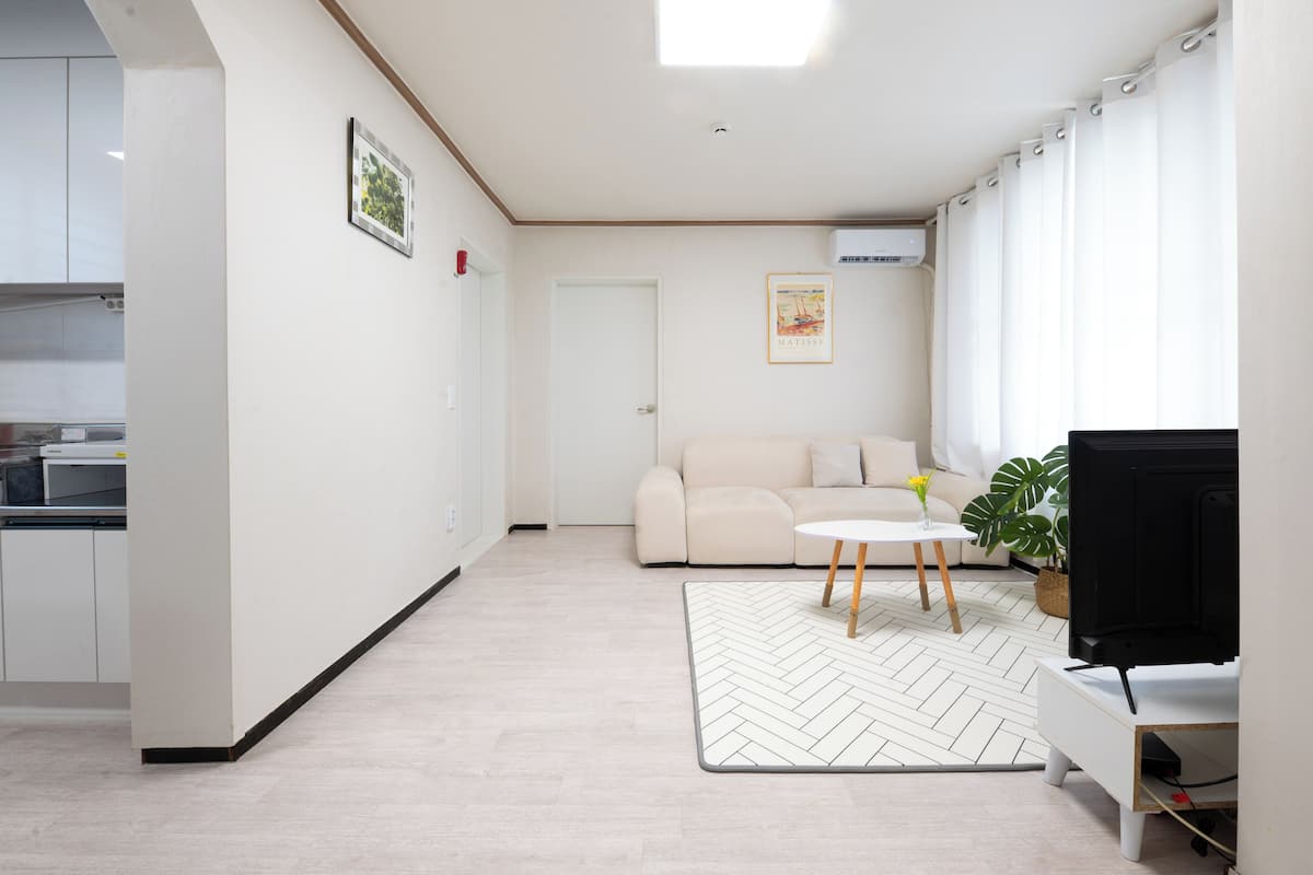 Una sala moderna con un sofá, una mesa de centro y un televisor.
