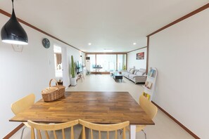 Un amplio salón con una mesa de comedor de madera, dos sillas, un sofá y una mesa baja.