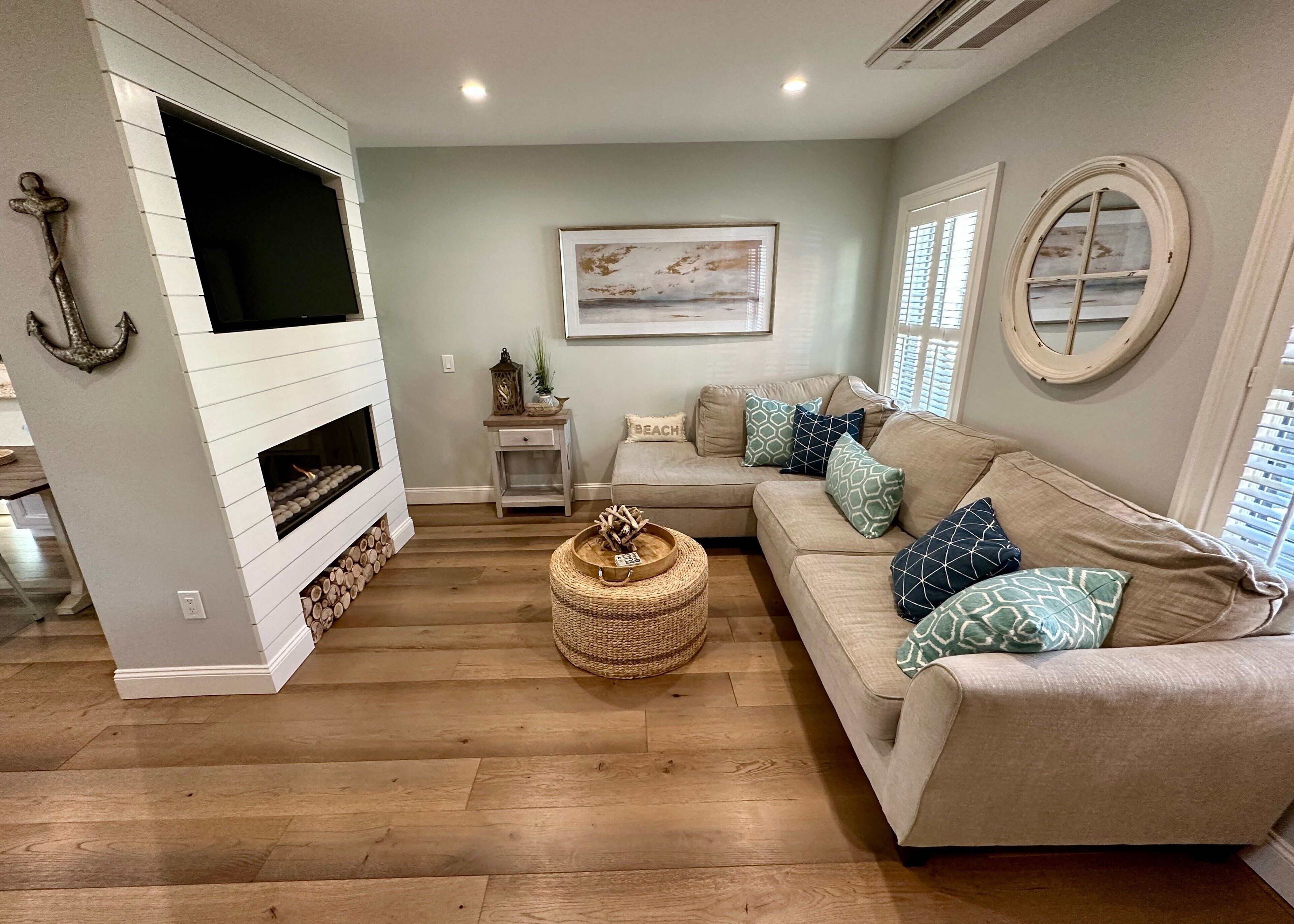 A living room with a fireplace, a sofa, a coffee table, and a painting on the wall.