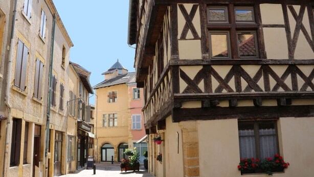 Eine enge Kopfsteinpflasterstraße, gesäumt von traditionellen Fachwerkhäusern.