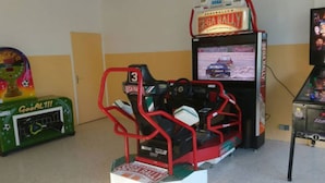 A gaming arcade with various racing games, including a prominent 'SEGA RALLY' machine. - 31m² Mobile Home with Terrace - 3 Bedrooms, Sleeps 6 (La Grande-Motte)