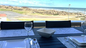 Ein Tisch für zwei Personen mit Blick auf das Meer und den Strand.