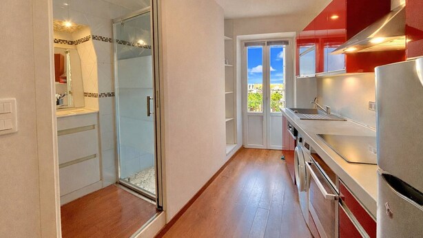 A modern kitchen with a sliding glass door leading to a balcony, a stainless steel refrigerator, and a red upper cabinet. - Studio 1 Room Center Ajaccio - Air Conditioning, Sleeps 4 (Ajaccio)
