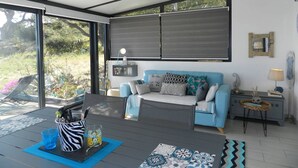 A modern living room with a blue sofa, a coffee table, and a TV. - 2-room apartment with terrace and parking in Le Lavandou (Le Lavandou)