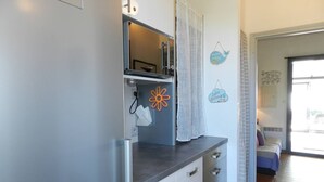 A kitchen with a refrigerator, a sink, and a countertop. There is a window with a view of the outside. - 2-room apartment with terrace and parking in Le Lavandou (Le Lavandou)